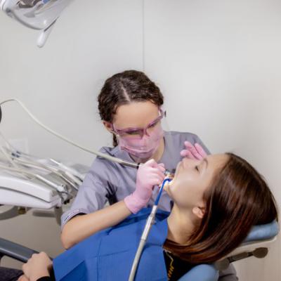 Dorosla Kobieta Odwiedza Gabinet Stomatologiczny Dlonie Dentysty W Gumowych Rekawicach Ochronnych Przy Uzyciu Bialego Kamienia Polerskiego Dla Pacjenta 130265 7559