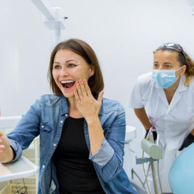 Szczesliwa Dojrzala Kobieta Po Leczeniu I Protetykach Patrzeje W Lustrze Przy Zebami 116407 5545